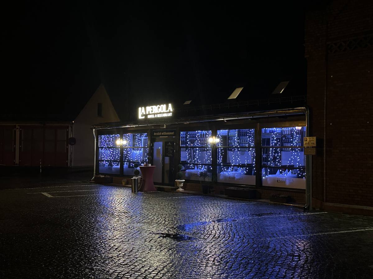 Das Haus La Pergola in Kolkwitz am Abend, beleuchtete Fensterfront