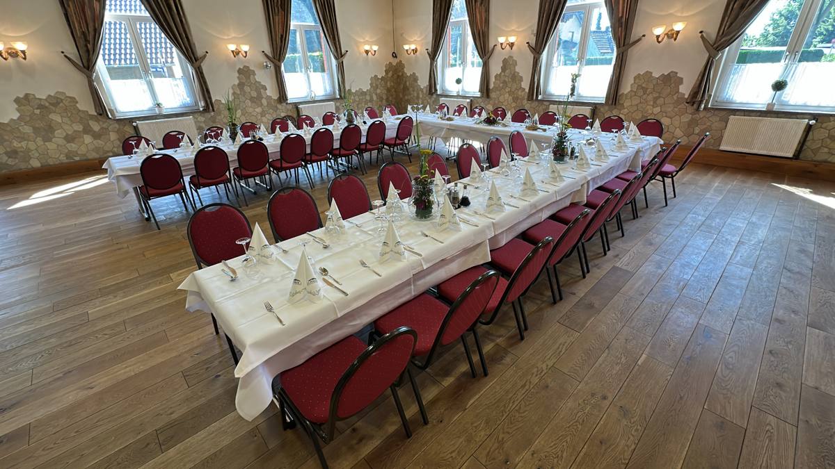 Festsaal mit langer, eingedeckter Tafel